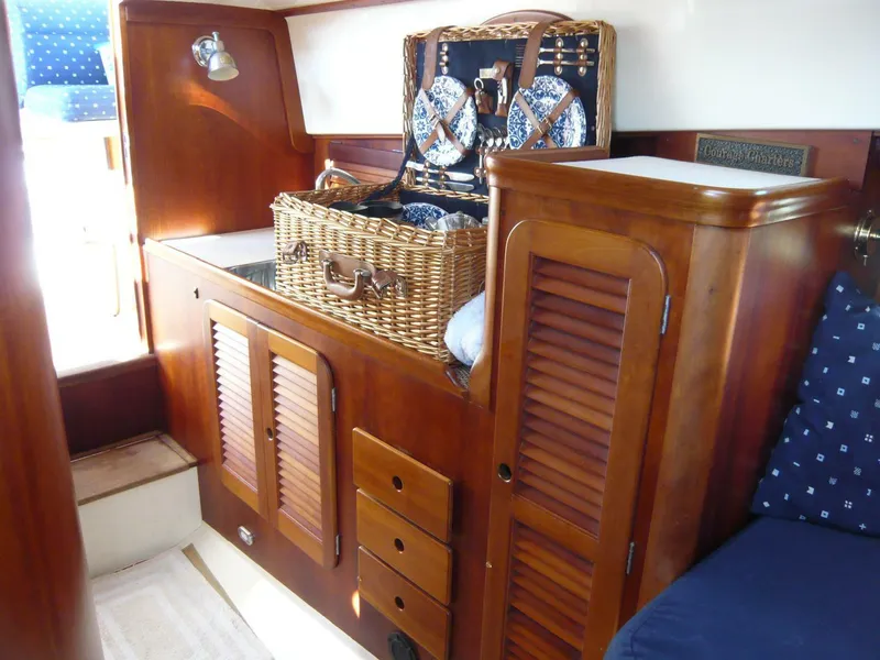 Slide: The Image of Interior of 1998 Hinckley 36 Classic yacht with wooden cabinetry and wicker picnic basket. - 23