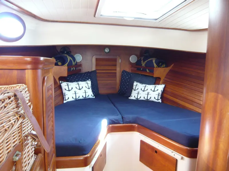 Slide: The Image of Cozy cabin interior of 1998 Hinckley 36 Classic with nautical-themed pillows and wooden finish. - 22