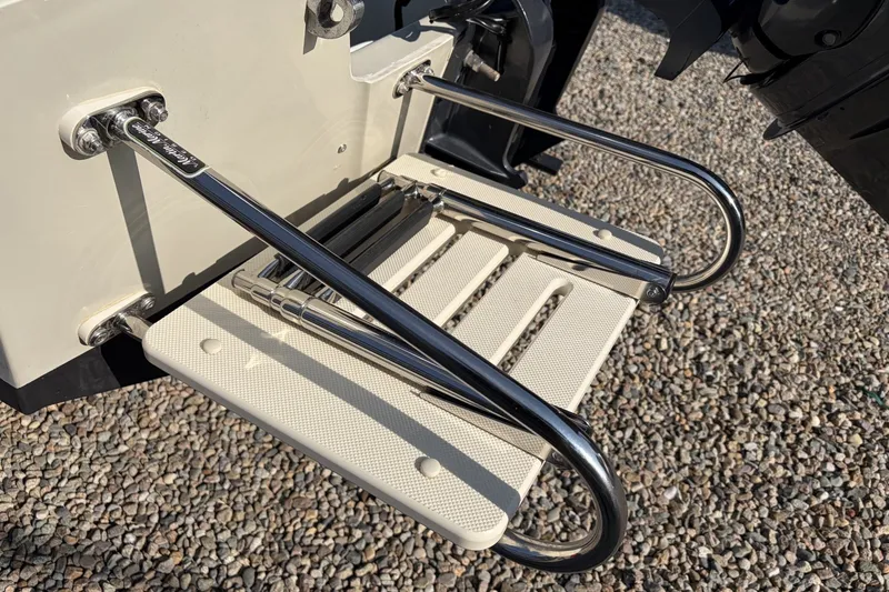 Slide: The Image of 1985 Boston Whaler 17 Montauk swim ladder with stainless steel rails on gravel surface. - 19