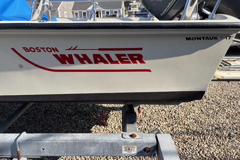 Slide: The Image of 1985 Boston Whaler 17 Montauk boat on trailer, showcasing brand logo and model name. - 15