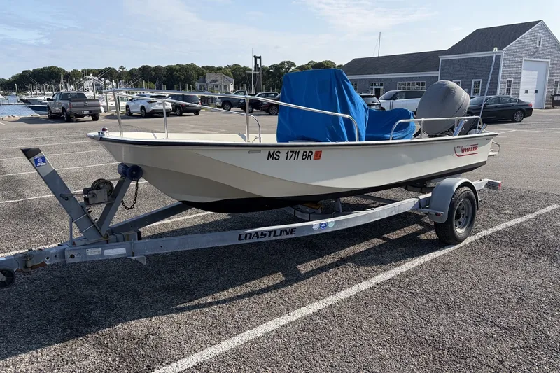 Slide: The Image of 1985 Boston Whaler 17 Montauk boat on trailer in parking lot near marina. - 17