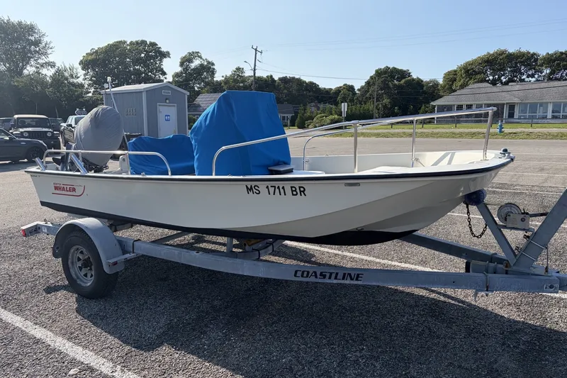 The Image of 1985 Boston Whaler 17 Montauk boat on trailer in parking lot. - 0