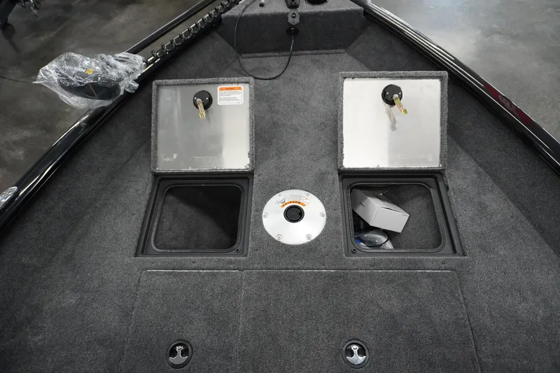 Slide: The Image of 2027 Tracker Pro Guide V-16 WT boat interior with storage compartments and carpeted flooring. - 17