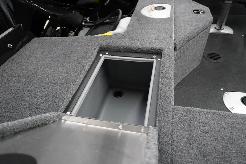 Slide: The Image of 2027 Tracker Pro Guide V-16 WT boat interior with storage compartment and carpeted flooring. - 3