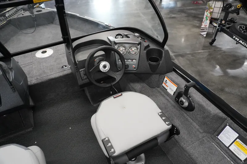 Slide: The Image of Interior of 2027 Tracker Pro Guide V-16 WT boat, featuring steering wheel and dashboard controls. - 7