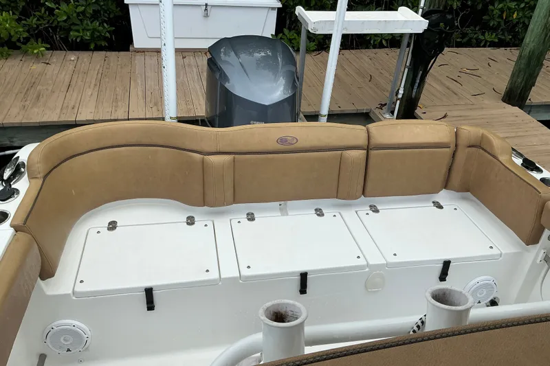 Slide: The Image of 2021 Sea Hunt Ultra 255SE boat interior with tan seating and storage compartments. - 7