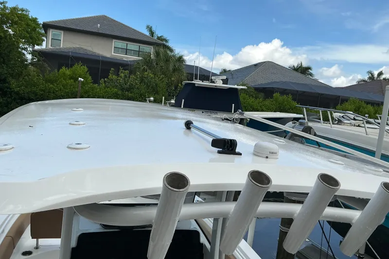 Slide: The Image of 2021 Sea Hunt Ultra 255SE boat docked, featuring rod holders and a sleek design. - 24