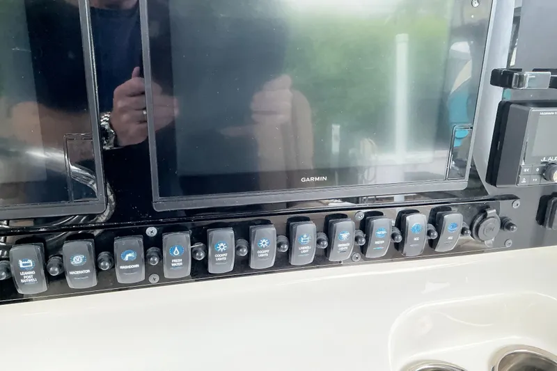 Slide: The Image of Control panel of a 2021 Sea Hunt Ultra 255SE boat with Garmin displays and switches. - 2