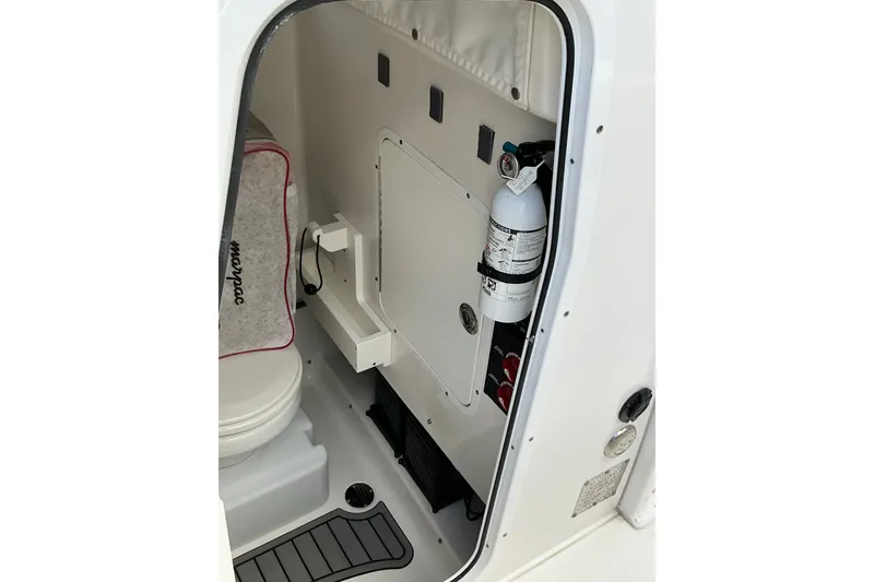 Slide: The Image of Interior of 2021 Sea Hunt Ultra 255SE boat, featuring a compact restroom and safety equipment. - 14