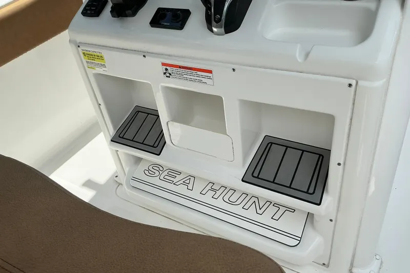 Slide: The Image of 2021 Sea Hunt Ultra 255SE boat console with storage compartments and controls. - 29