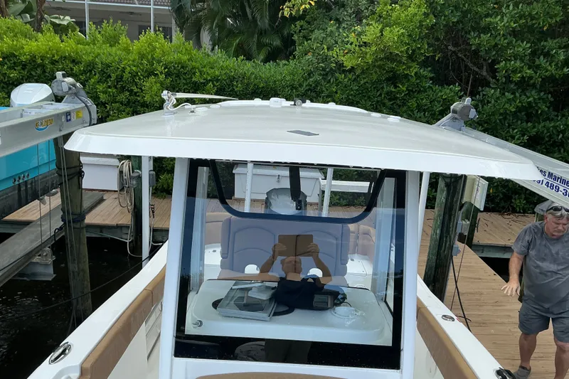 Slide: The Image of 2021 Sea Hunt Ultra 255SE boat docked, featuring sleek design and spacious interior. - 12