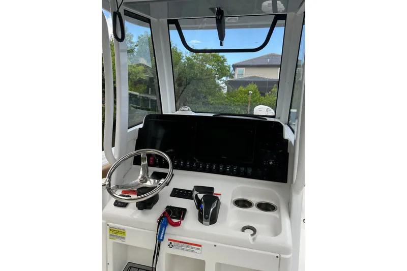 Slide: The Image of 2021 Sea Hunt Ultra 255SE boat dashboard with steering wheel and control panel. - 6
