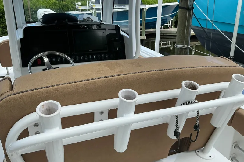 Slide: The Image of 2021 Sea Hunt Ultra 255SE boat cockpit with rod holders and steering console. - 26