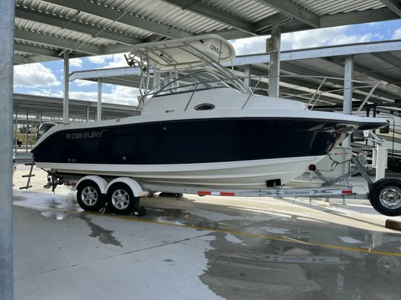 The Image of A 2006 Century 2400 Walk-Around boat on a trailer in a covered area. - 0