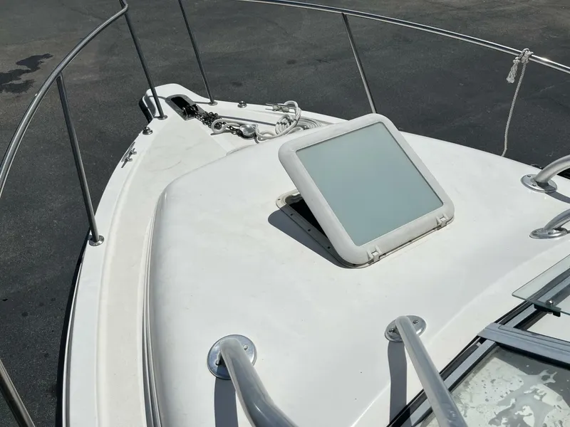 Slide: The Image of The image shows the bow of a 2006 Century 2400 Walk-Around boat with an anchor and hatch. - 13