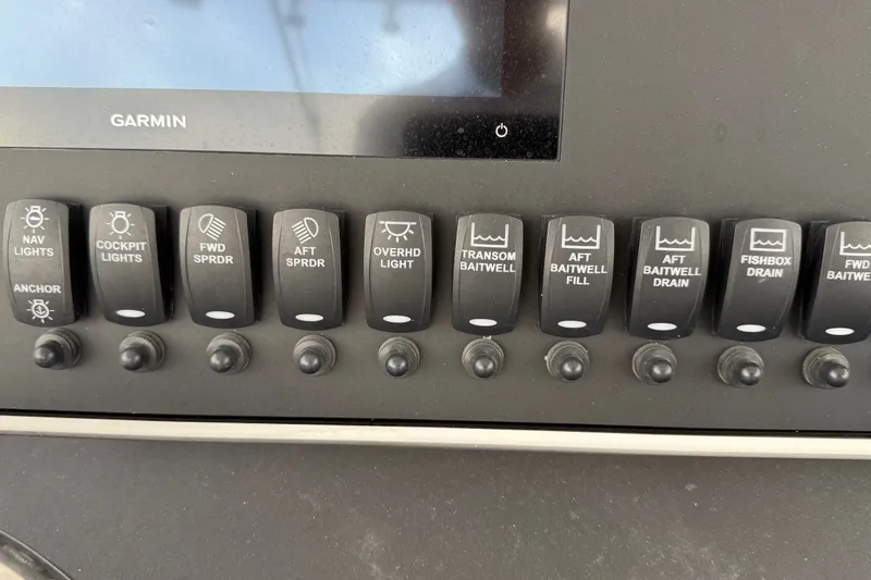 Slide: The Image of Control panel of a 2007 SeaCraft SC 32 Master Angler with labeled switches and Garmin display. - 16