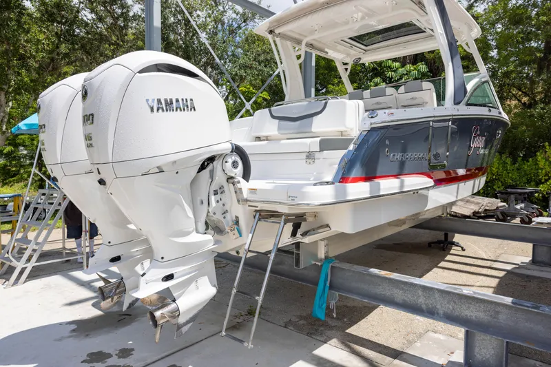 Slide: The Image of 2023 Chaparral 300 OSX with twin Yamaha outboard engines on a boat stand. - 3