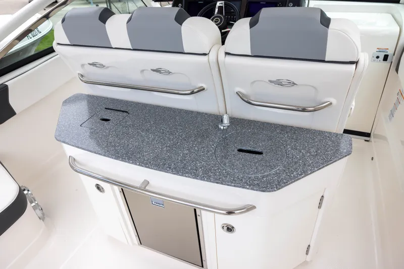 Slide: The Image of The 2023 Chaparral 300 OSX features a sleek kitchenette with a gray countertop and white seating. - 7
