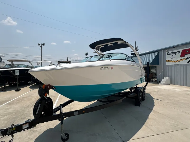 Slide: The Image of 2020 Regal LS4 Surf at a marina, featuring a blue hull and black canopy. - 4