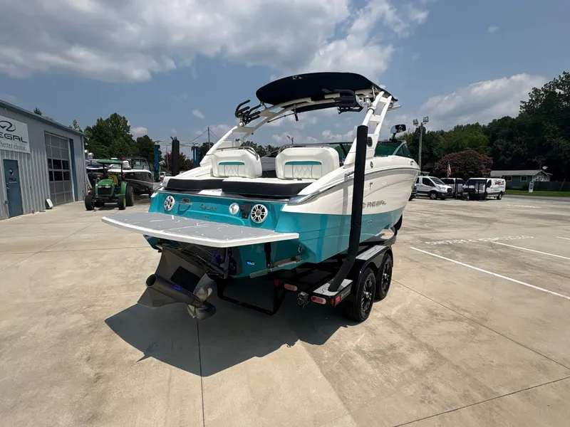 Slide: The Image of 2020 Regal LS4 Surf in turquoise and white, on a trailer, with tower and speakers. - 8