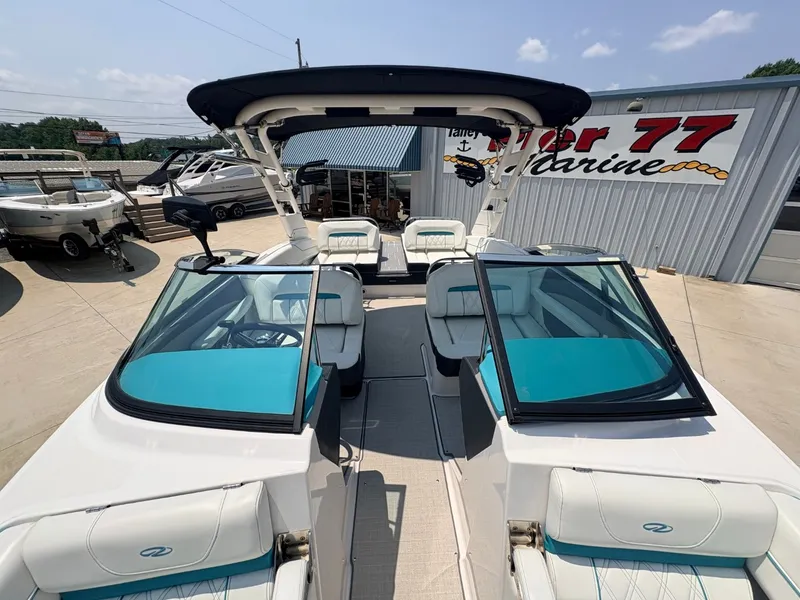 Slide: The Image of The image shows a 2020 Regal LS4 Surf boat with turquoise seats and a black sunshade. - 22