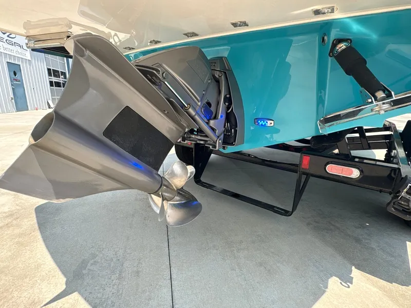 Slide: The Image of The image shows the stern of a 2020 Regal LS4 Surf boat with a blue hull and propeller. - 24