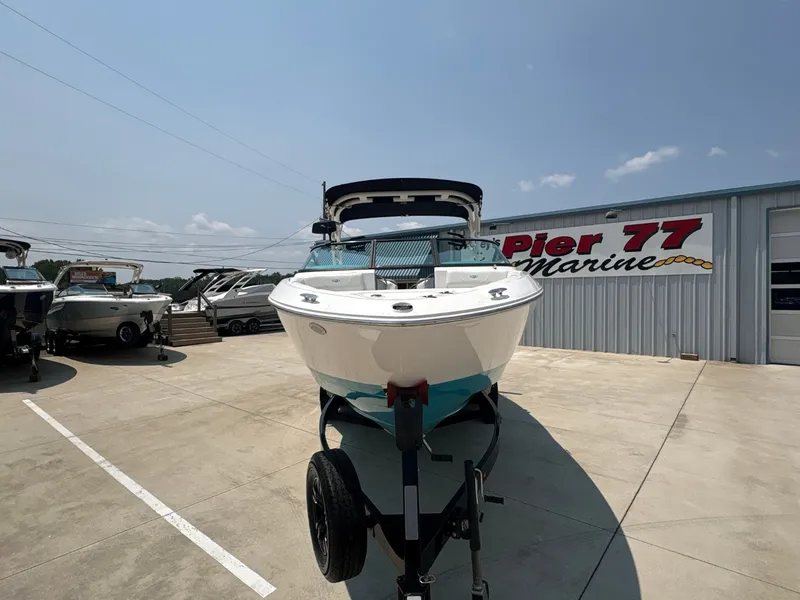Slide: The Image of A 2020 Regal LS4 Surf boat on a trailer in front of a building labeled "Pier 77 Marine." - 11