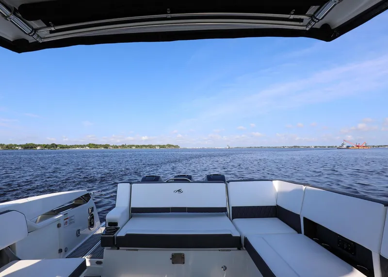 Slide: The Image of 2023 Monterey 385 Super Sport boat with spacious seating, overlooking a serene water view. - 20