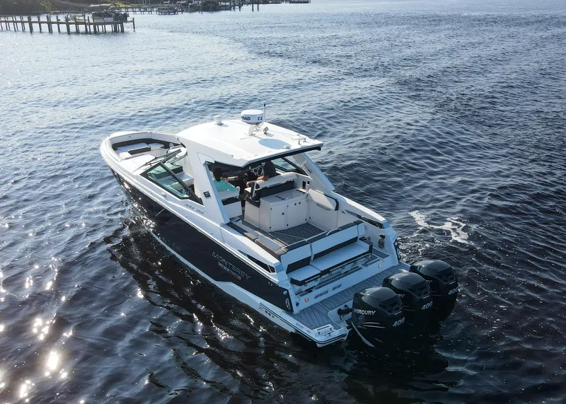 Slide: The Image of 2023 Monterey 385 Super Sport boat cruising on open water, rear view. - 8