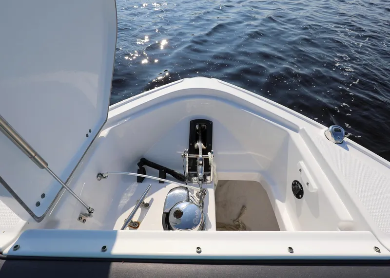 Slide: The Image of 2023 Monterey 385 Super Sport boat anchor compartment with open hatch on calm water. - 31