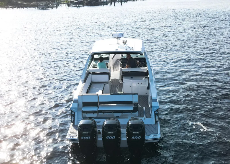 Slide: The Image of 2023 Monterey 385 Super Sport boat cruising on open water, rear view. - 2