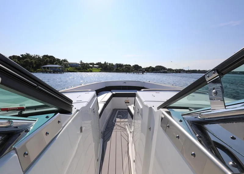 Slide: The Image of 2023 Monterey 385 Super Sport boat cruising on a sunny day, showcasing sleek design and open water. - 25