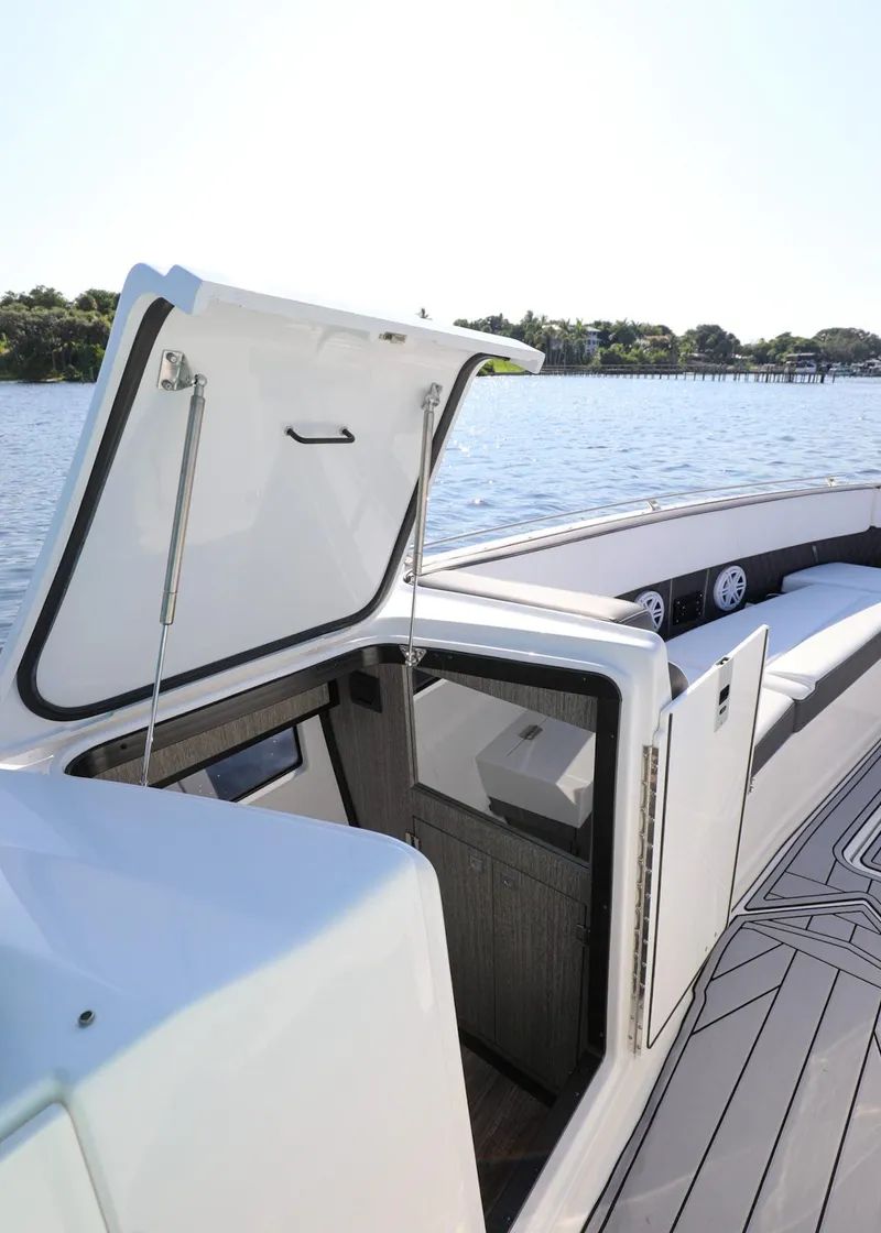 Slide: The Image of 2023 Monterey 385 Super Sport boat with open hatch, docked on a sunny day. - 30