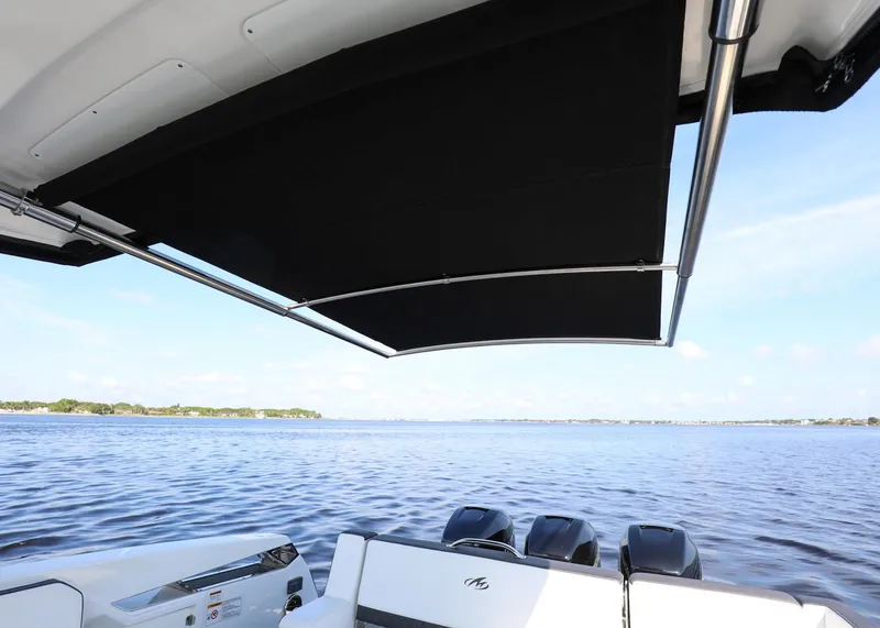 Slide: The Image of 2023 Monterey 385 Super Sport boat with canopy, overlooking serene water. - 15