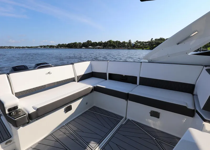 Slide: The Image of 2023 Monterey 385 Super Sport boat interior with seating, overlooking a serene water view. - 18
