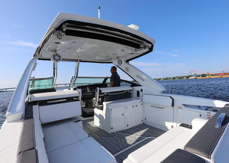 Slide: The Image of 2023 Monterey 385 Super Sport boat interior with seating, helm, and open water view. - 17