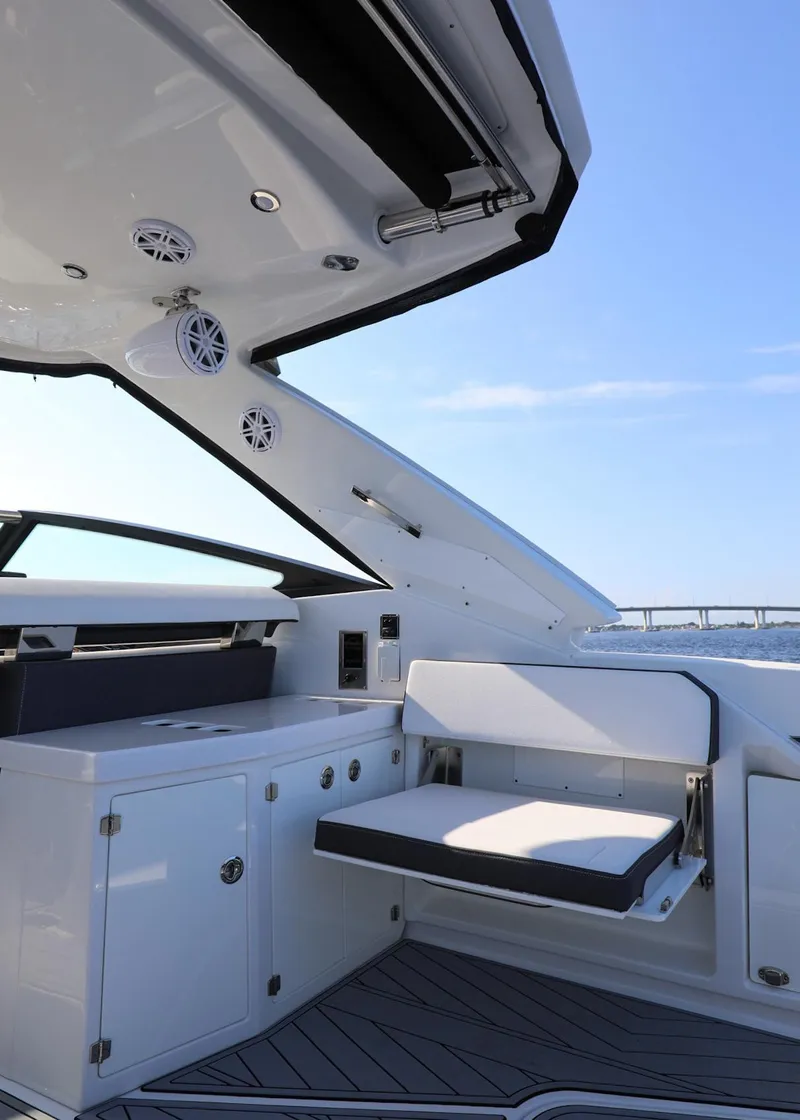 Slide: The Image of 2023 Monterey 385 Super Sport yacht interior with seating and cabinetry, under a clear blue sky. - 12