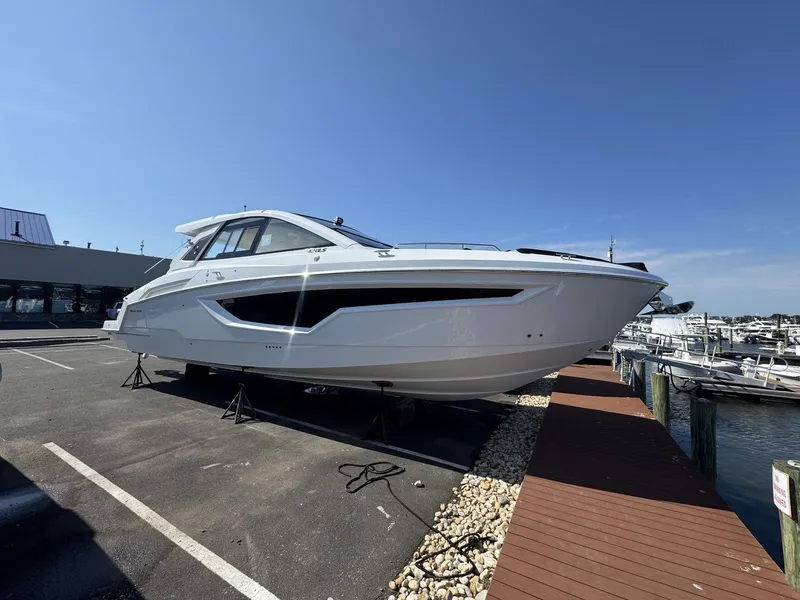 Slide: The Image of A modern 2027 Cruisers Yachts 42 GLS OB is parked on a lot beside a dock. - 0