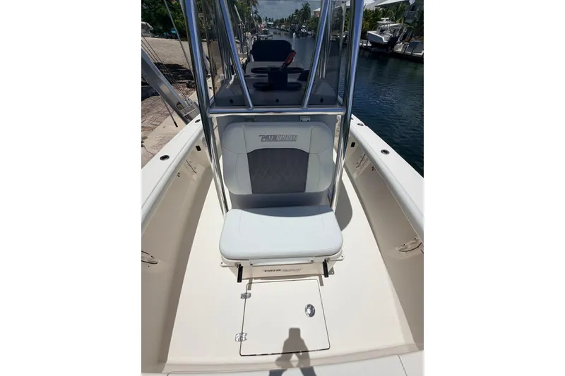 Slide: The Image of 2023 Pathfinder 2400 Open boat interior with seating and console, docked by the water. - 7