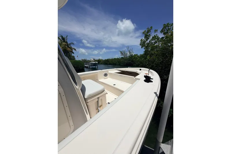 Slide: The Image of 2023 Pathfinder 2400 Open boat docked near lush greenery under a clear blue sky. - 5