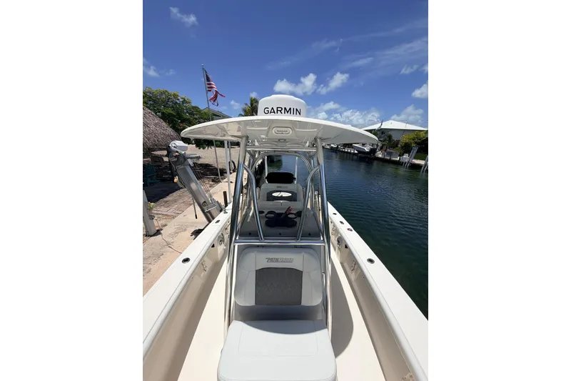 Slide: The Image of 2023 Pathfinder 2400 Open boat docked by a canal under a clear blue sky. - 6