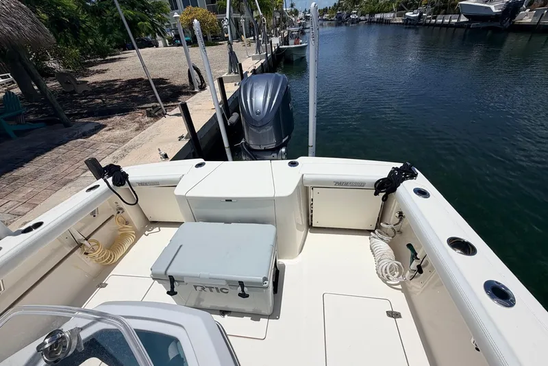 Slide: The Image of 2023 Pathfinder 2400 Open boat docked by a serene canal, featuring a spacious deck. - 10