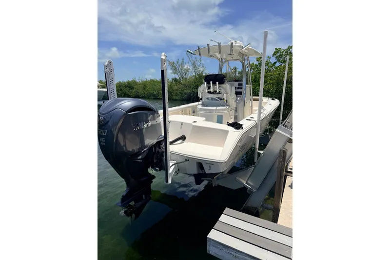 Slide: The Image of 2023 Pathfinder 2400 Open boat with Yamaha engine on a lift by the water. - 13
