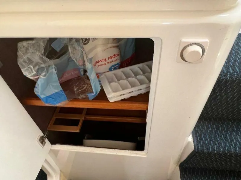 Slide: The Image of A storage compartment on a yacht with an ice cube tray and paper towels. - 27