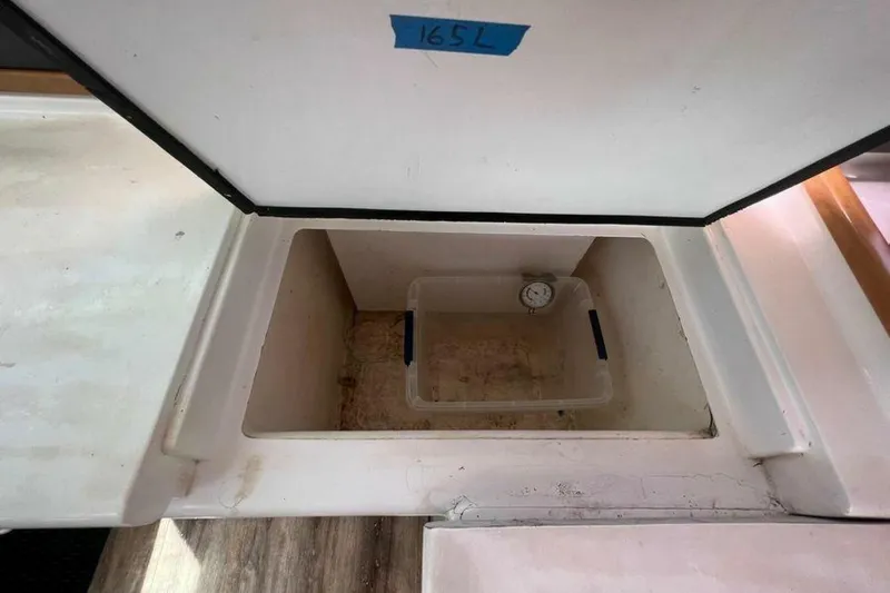 Slide: The Image of An open storage compartment on a yacht with a small container and a thermometer. - 36
