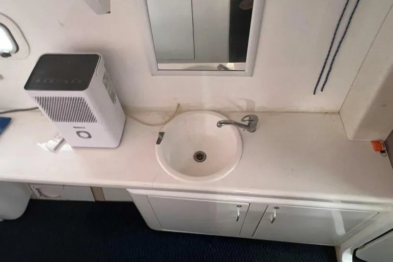 Slide: The Image of The image shows a sink with a faucet and a mirror above. A dehumidifier is nearby. - 18