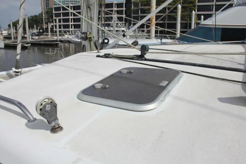 Slide: The Image of The image shows the deck of a 1995 Voyage Yachts Mayotte with a hatch and rigging. - 48