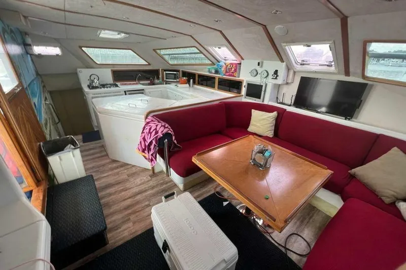 Slide: The Image of Interior of a 1995 Voyage Yachts Mayotte with red sofa and wooden table. - 13