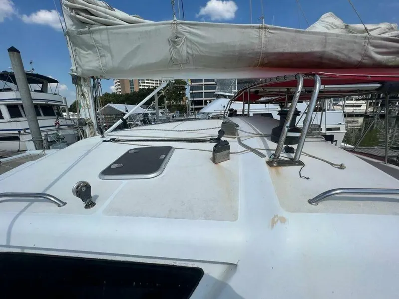 Slide: The Image of The image shows the deck of a 1995 Voyage Yachts Mayotte with sails and a marina in the background. - 4