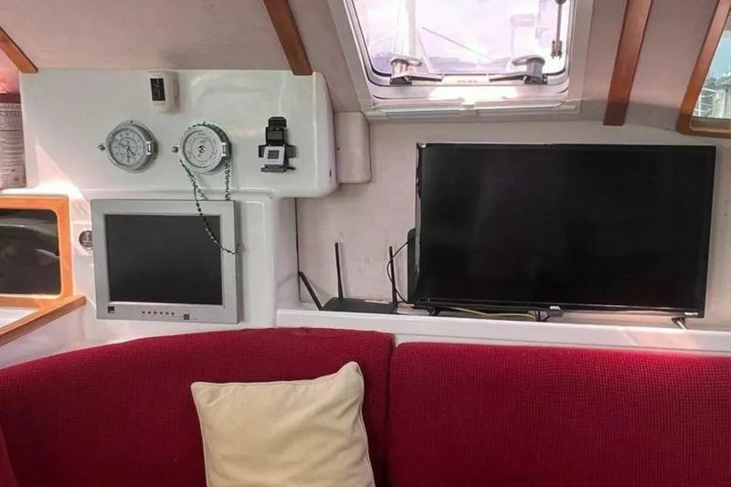 Slide: The Image of The yacht interior features a red sofa, a window, a TV, and instruments. - 32